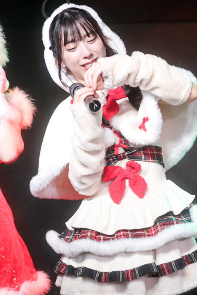 embellir(あんべりー)の水野ひなた(みずのひなた)ちゃんをライブ中に撮影した写真。
ゆきんこ衣装を着ている。
手で「雪だるま」のジェスチャーをしている。
2025年12月25日GOTANDA G3　冠Fes Xmas SP!にて撮影。