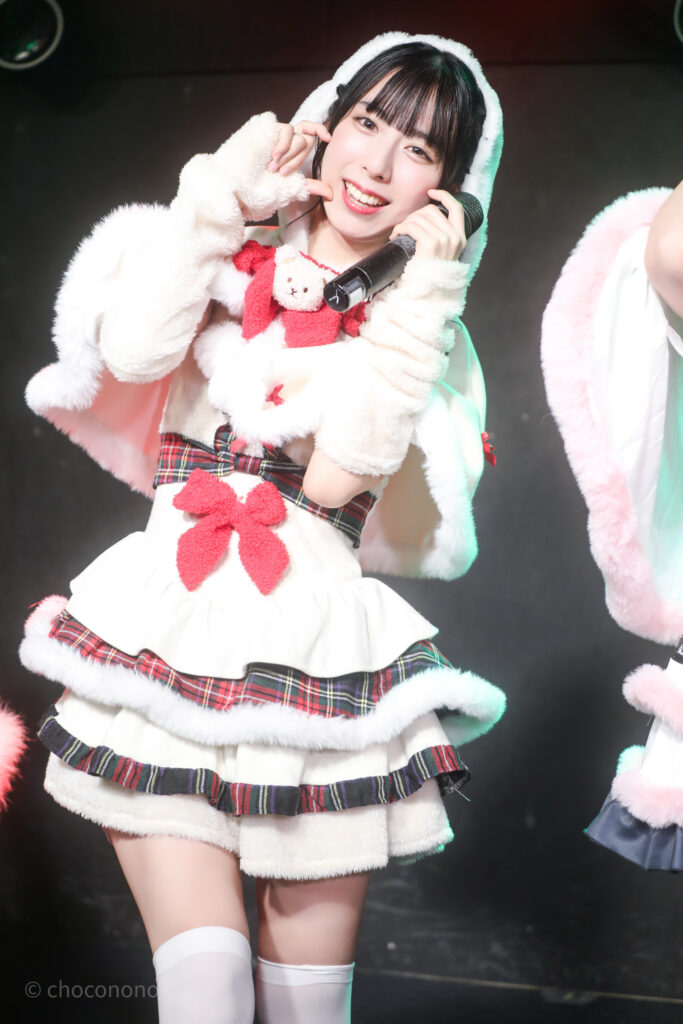 embellir(あんべりー)の水野ひなた(みずのひなた)ちゃんをライブ中に撮影した写真。
ゆきんこ衣装を着ている。
両手をほっぺたのところに当てて「ハートに入っている」
2025年12月25日GOTANDA G3　冠Fes Xmas SP!にて撮影。