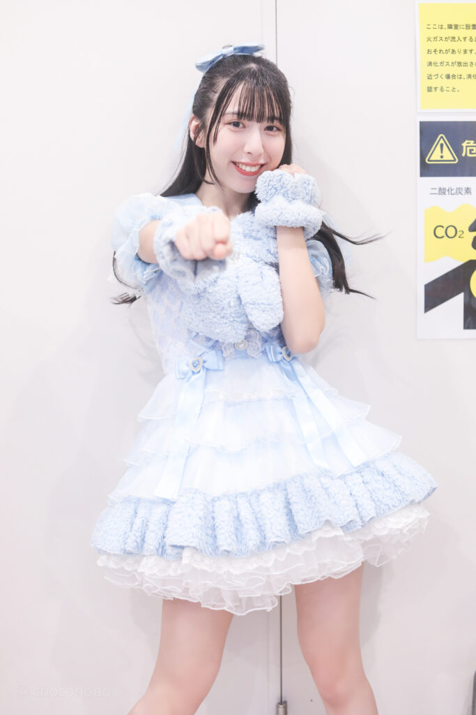 embellir(あんべりー)の水野ひなた(みずのひなた)ちゃんを特典会で撮影した写真。
拳を前に真っ直ぐ突き出しながら微笑んでいる。
2025年12月31日SHIBUYA ONE5　ONE5 SHUFFLE FESTIVALにて撮影。