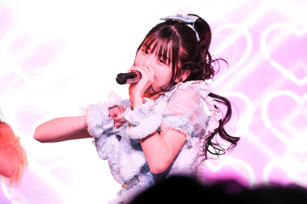 embellir(あんべりー)の水野ひなた(みずのひなた)ちゃんをライブ中に撮影した写真。
ダンスに合わせてくるくる巻かれたポニーテールの束がふわっと浮いていて可愛い。
2025年12月31日SHIBUYA ONE5　ONE5 SHUFFLE FESTIVALにて撮影。