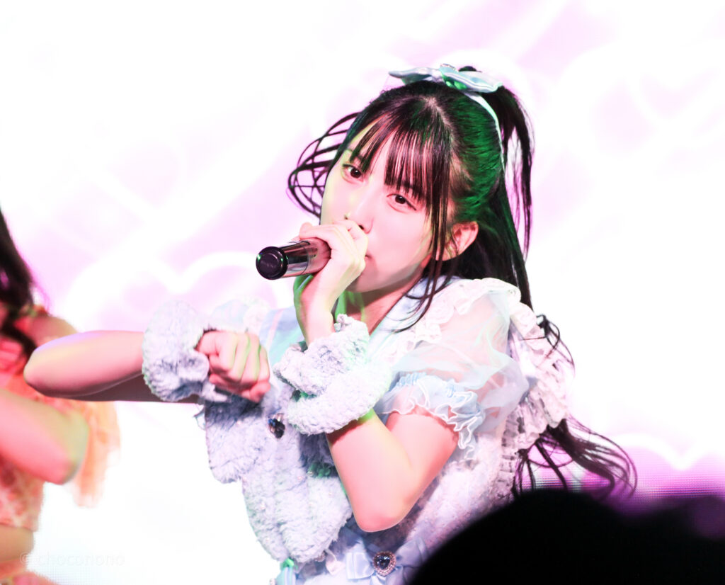 embellir(あんべりー)の水野ひなた(みずのひなた)ちゃんをライブ中に撮影した写真。
ダンスに合わせてくるくる巻かれたポニーテールの束がふわっと浮いていて可愛い。
2025年12月31日SHIBUYA ONE5　ONE5 SHUFFLE FESTIVALにて撮影。