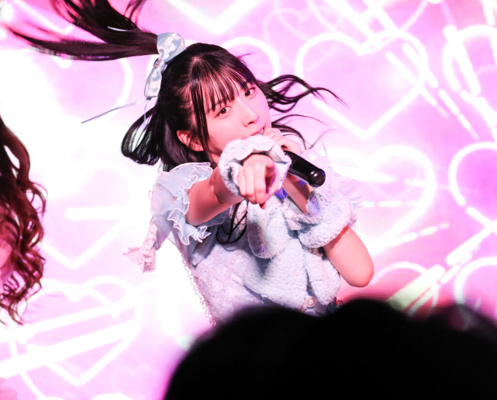 embellir(あんべりー)の水野ひなた(みずのひなた)ちゃんをライブ中に撮影した写真。
真っ直ぐにこちらを見つめながら指さしてくれている。
2025年12月31日SHIBUYA ONE5　ONE5 SHUFFLE FESTIVALにて撮影。